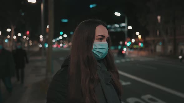Female Model Wearing Mask Against Virus Walking Alone in the Night City alt