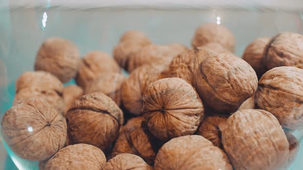 In a Transparent Round Bowl There are Walnuts Covered with a Shell Bumpy Pattern alt