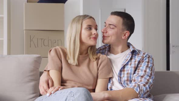 Happy Family Householders with Kid Sitting on Couch at New Home at Moving Day