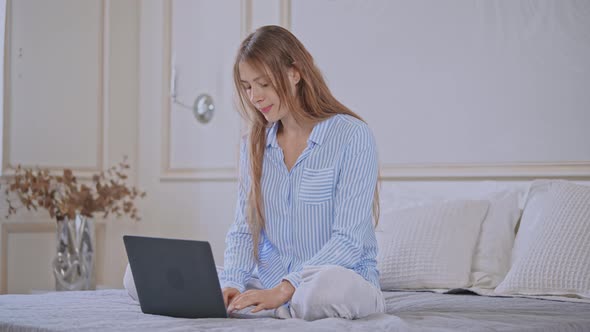 Young Female Use Computer in Bedroom