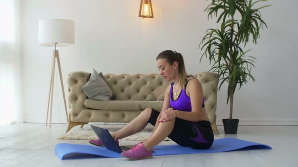 Fit Woman Watching Online Video with Exercises on Laptop alt