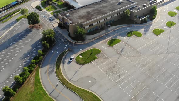 person riding electric skateboard in parking lot with helmet car driving aerial drone alt