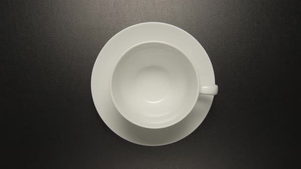 White coffee cup is rotating on black background
