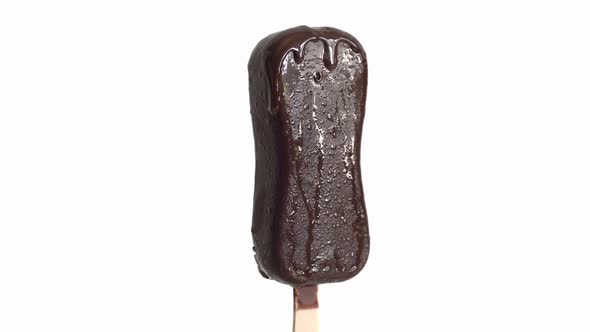 White Ice Cream Melts On A Wooden Stick. The Chocolate Flows Down. alt