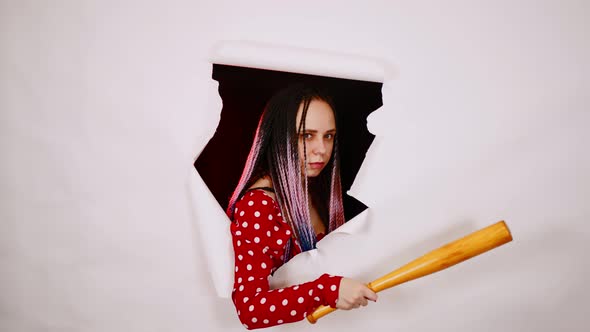 Young Woman with Baseball Bat in Hole of White Background alt