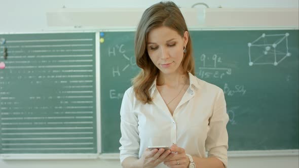 Female Teacher or Student Text Message with a Phone at Classroom in ...