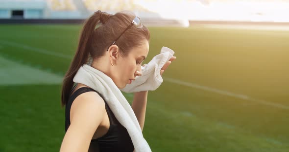 Woman Wiping Sweat on Stadium