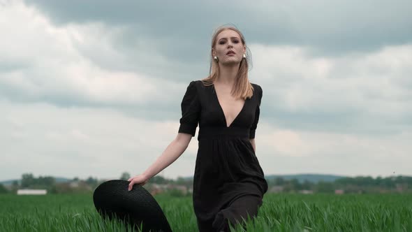 Flamboyant Girl In Black Dress Goes By The Field. alt