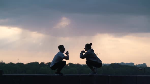 Couple Doing Exercises on the Background of the City