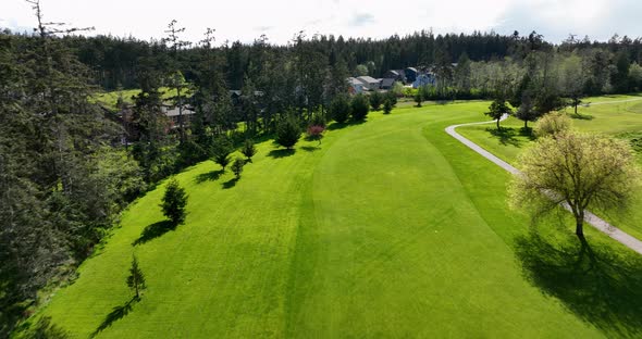 Aerial view of a driving range bordering a suburban neighborhood. alt