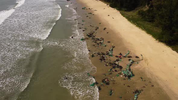 Aerial view of tropical sandy beach in Vietnam with plastic fishing net washed out after thyphoon st alt