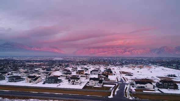 Utah Valley in winter during colorful sunset with houses in snow alt