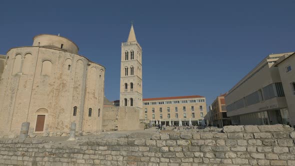 Ruins and churches in a sunny square alt