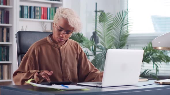 Overjoyed African American Business Woman with Calculator in Office alt