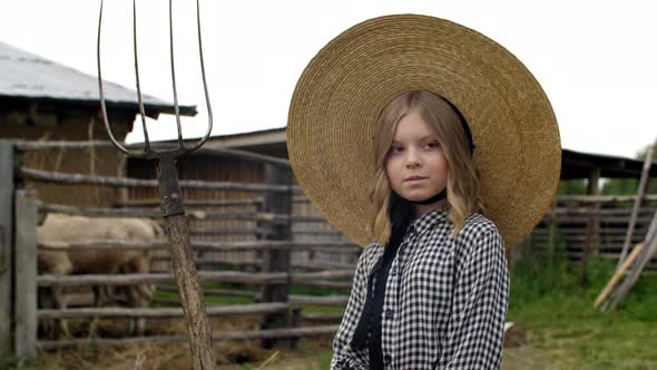 Beautiful Girl in Hat Holding Pitchfork on Rural Farm alt