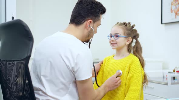 Portrait of Charming Caucasian Girl Inhaling and Exhaling As Doctor Using Stethoscope alt