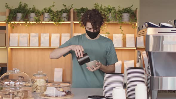 Young Man Making Cappuccino in Coffeeshop alt