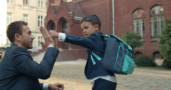 Young Father in Suit and Teen Boy Doing Goodbye Ritual Before Going To School, Child in Uniform alt