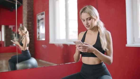 Beautiful Woman Using Smartphone in Fitness Club alt