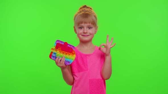 Child Girl Holding Many Colorful Squishy Silicone Bubbles Pop It Popular Sensory Toys Thumb Up alt