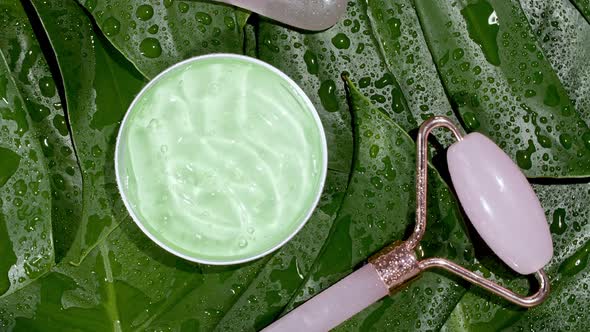 Green Cosmetic Cream with Rotation on Background of Tropical Leaves Monstera alt