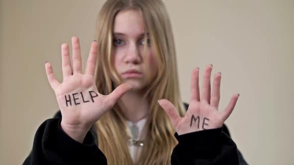 Portrait of a Frustrated Teenage Girl Showing Her Palms with the Inscription HELP ME
