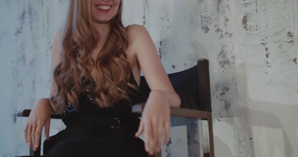 Glamour Lady Poses on Chair and Throws Her Legs with Shoes on Table at Camera alt