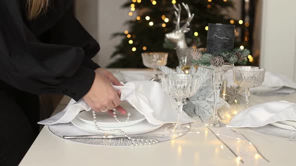Woman hands decorating and serving festive table for the Christmas holidays. alt