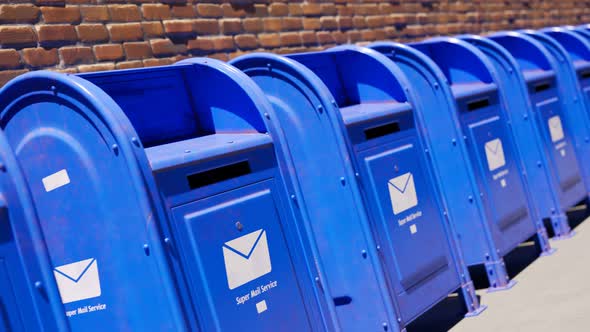 Endless row of blue mailboxes against a brick wall. Seamless looping animation. alt