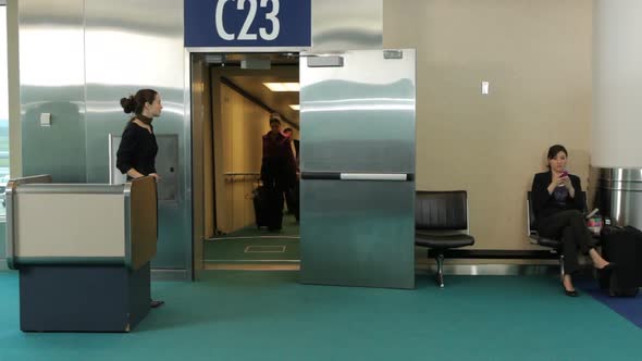 Airport passengers walk out of jet way door alt