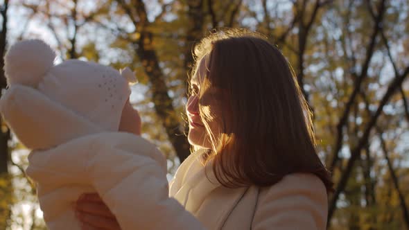 Mother with baby in her arms in the park in autumn