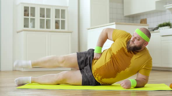 Sweaty Man in Wet Sportswear Doing Legs Lifting Exercises Lying on Mat at Home