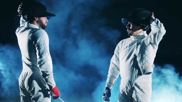 Two Athletes are Putting Their Masks on and Preparing to Fence alt