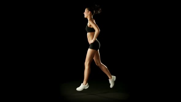 Young Athletic Woman Wearing Sporstwear is Exercising Isolated on Black alt