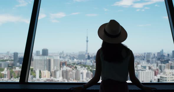 Woman enjoy the view of Tokyo city at observation deck alt