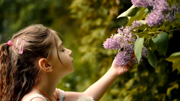 Cute Baby Girl Adorable Little Smelling Flower. Happy Beautiful Kid With Pretty Face Having Fun. alt