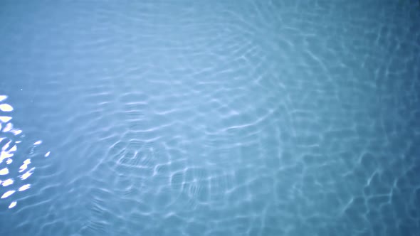 Slo-motion water rippling against blue background alt