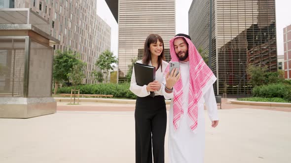 Diverse Businesspeople Using Smartphone on Street Together alt