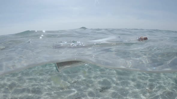 Glass bottle with message floats in transparent water of sea or ocean alt