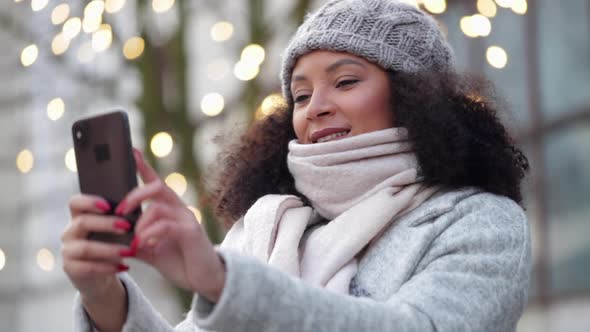 Woman Taking Selfie on Mobile Phone Outside on Winter Street Spbi alt