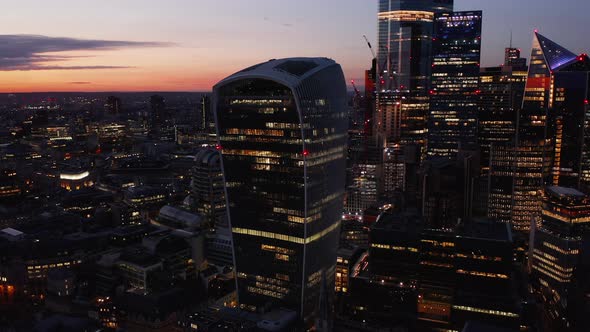 Slide and Pan Footage of Modern Futuristic Office Buildings in City Financial Hub After Sunset alt