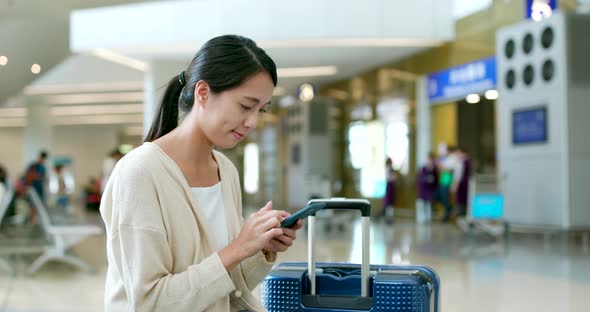 Woman use of mobile phone in airport alt