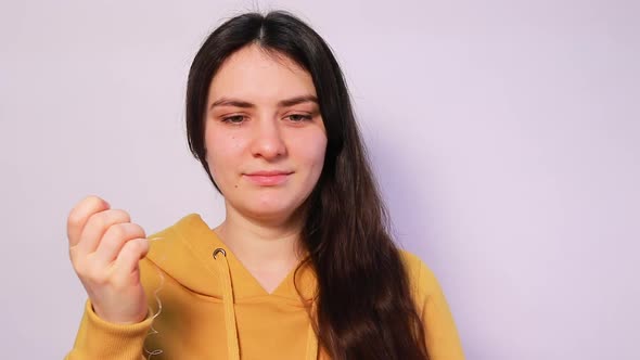 A Brunette Woman Brushes Her Teeth with Flossing