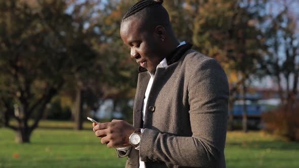 African-American Man Chatting in Smartphone, Outdoors