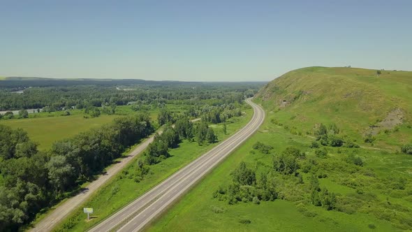 Aerial: Flying Over Highway in the Highlands. View of the Tourist City, Mountain River alt
