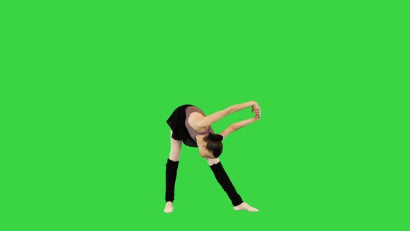 Young Ballerina in Training Clothes Makes a Warmup on a Green Screen Chroma Key alt