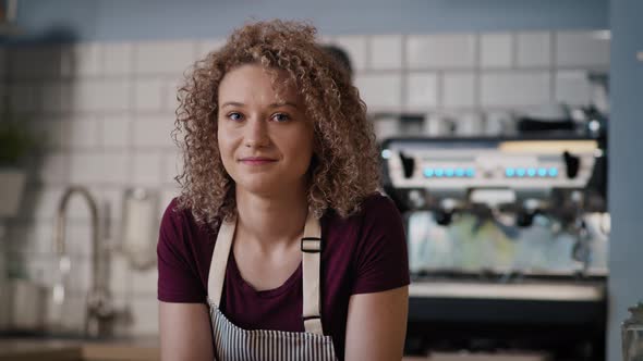 Portrait of young caucasian waitress in the bakery. Shot with RED helium camera in 8K. alt