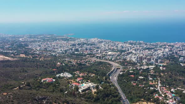 Flying above a highway looking over the sprawling city towards the Mediterranean alt
