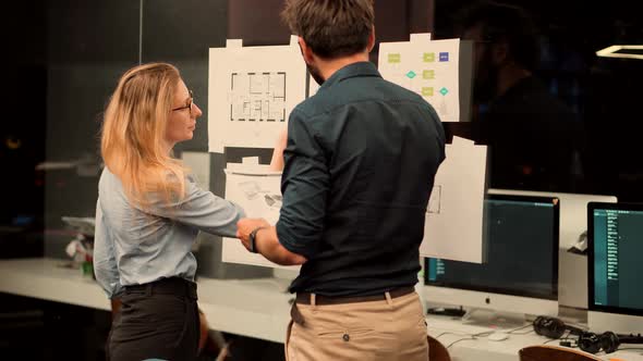 Teamwork Cooperating In Working Together At Computer Workplace. Two Colleagues Talking In Office. alt