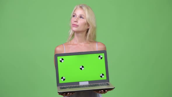 Young Happy Beautiful Businesswoman Thinking While Showing Laptop